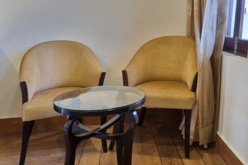 two chairs and a glass table in a room at Labh Garh Palace Resort & Spa in Udaipur