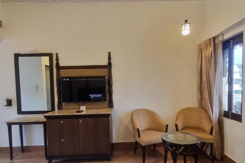 a room with two chairs and a table and a mirror at Labh Garh Palace Resort & Spa in Udaipur