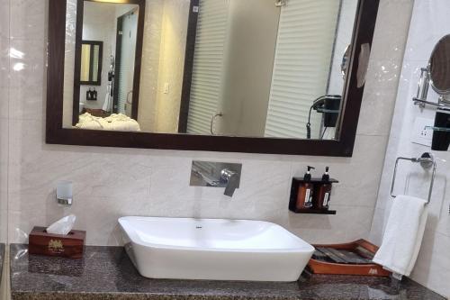 a bathroom with a sink and a large mirror at Labh Garh Palace Resort & Spa in Udaipur