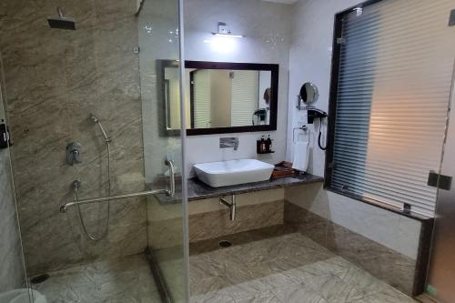 a bathroom with a sink and a shower with a mirror at Labh Garh Palace Resort & Spa in Udaipur