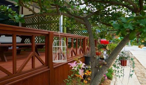 a wooden fence with a bird cage hanging from a tree at Buan Mul Love Pension in Buan