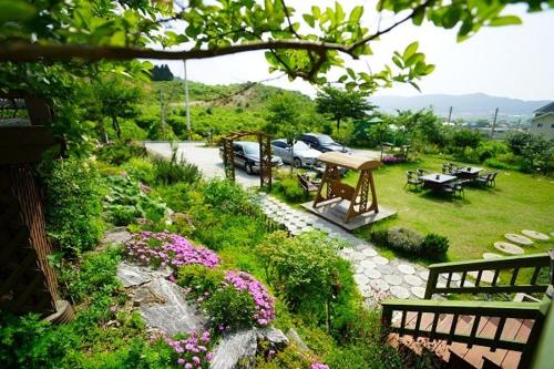 a garden with a picnic table and benches and flowers at Pension on the Sea Shore in the Bosom Department Byeonsanbando in Buan
