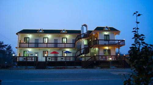 a large white house with lights on it at night at Anmyeondo Taean Romance Pension in Taean