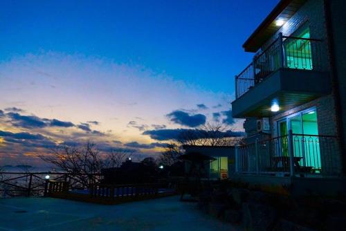 a building with lights on the side of it at dusk at Byeonsanbando Badajeonmangdae Pension in Buan