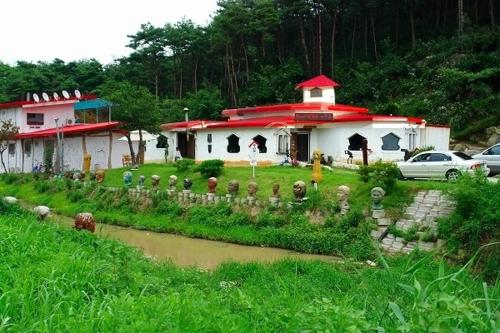 a building with a river in front of it at Buan Bbalgan Jibung Pension in Buan