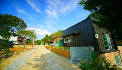 a black house on the side of a road at Namusori pension in Goesan
