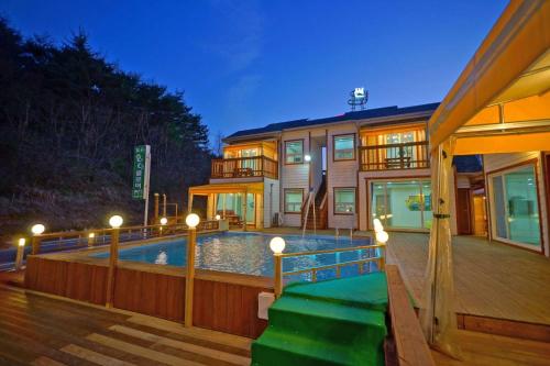 a house with a swimming pool in front of a house at anmyeondo neipkeulrobeo suyeongjangpensyeon in Chŏkkae