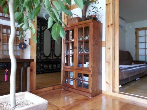 a room with a wooden cabinet with a tree in it at Jeonju Hanok-an hanok an Pension in Jeonju