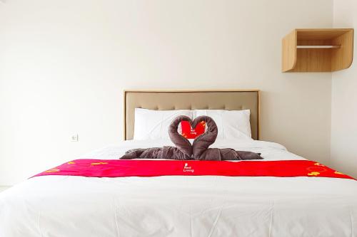 two swans laying on top of a bed at RedLiving Star Apartemen Semarang - UMAKU Lantai 16 in Jomblang