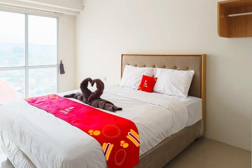 a bedroom with a bed with a stuffed animal on it at RedLiving Star Apartemen Semarang - UMAKU Lantai 16 in Jomblang