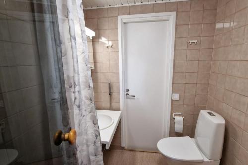 a bathroom with a toilet and a sink and a shower at Villa Ruths Stay Lehmus in Kouvola