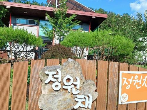 a wooden fence with a sign in front of a house at Private pension Jeongwonchae in Wanju