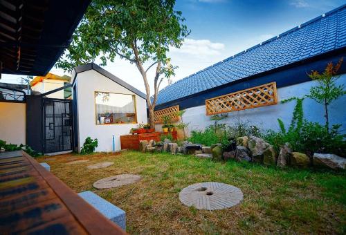 un patio trasero de una casa con un jardín con rocas en Jeonju Hanok Geugot Stay, en Jeonju