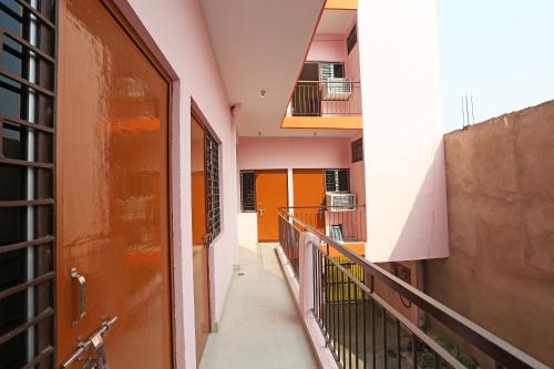 an empty hallway of a building with an orange door at Super Hotel O Shree Shree Guest House in Varanasi
