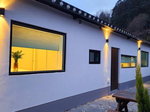 a white house with a window and a wooden bench at Byeoldul Private Pension in Jeonju