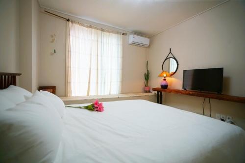 a bedroom with a white bed with a flower on it at Jeonju Hanok Village Dohwaseoga Stay Private Pension in Jeonju