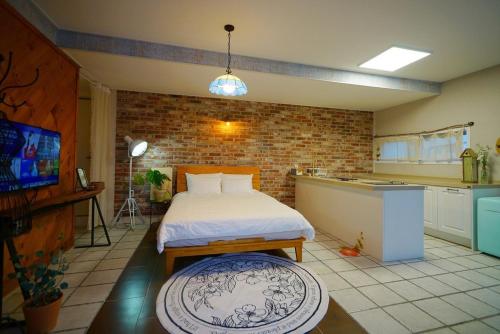 a bedroom with a bed and a kitchen with a tv at Jeonju Hanok Village Dohwaseoga Stay Private Pension in Jeonju
