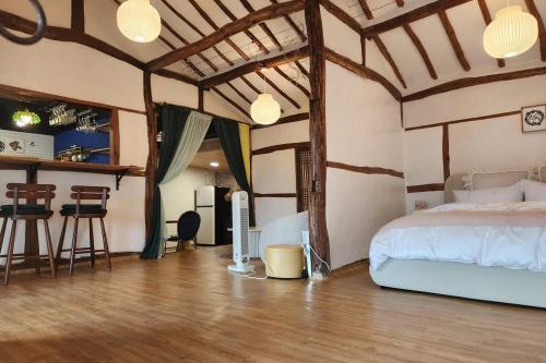 a bedroom with a bed and a kitchen with a bar at Hue Hanok Guesthouse in Buan