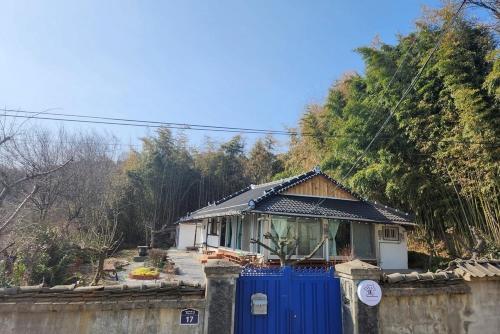 a house with a blue gate and a fence at Hue Hanok Guesthouse in Buan