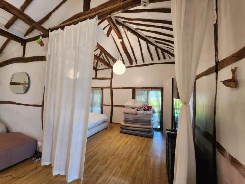 a room with a bed and curtains in a room at Hue Hanok Guesthouse in Buan