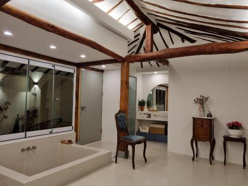 a bathroom with a tub and a chair and a table at Jeonju Hanokmaeul Nest175 Jaczzi Dokchae Pension in Jeonju