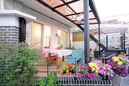 a porch with flowers and a table on it at Jeonju Hanok Village Artist’s House Sigan Moonui in Jeonju