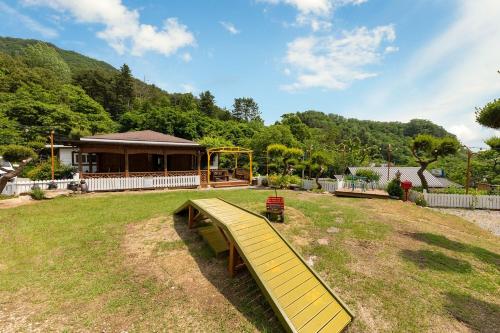 a playground in a yard with a house at Gapyeong Petmily Dog Pension in Gapyeong