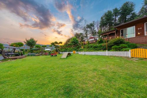 a yard with a bench in the grass at Gapyeong Petmily Dog Pension in Gapyeong