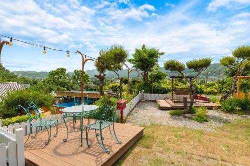 a patio with a table and chairs in a yard at Gapyeong Petmily Dog Pension in Gapyeong