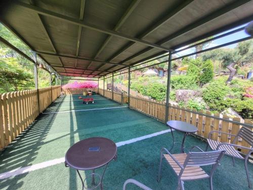 a covered patio with tables and chairs and flowers at Gapyeong Petmily Dog Pension in Gapyeong