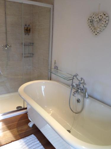 a white bath tub in a bathroom with a shower at Fernside Bed and Breakfast in Templeton