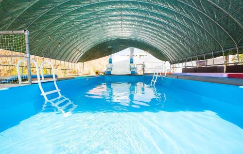 a large swimming pool with a curved roof at Jeongpo Pension in Taean