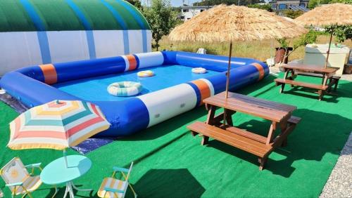 a large inflatable couch with a table and benches at Mongsanpo High Beach Pension in Taean