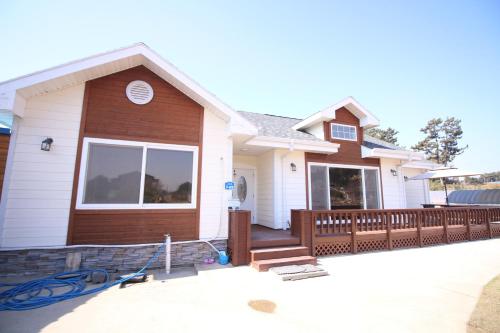 a house with a wooden fence in front of it at Mongsanpo High Beach Pension in Taean