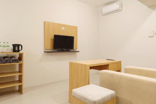 a living room with a couch and a table with a tv at RedLiving Star Apartemen Semarang - UMAKU Lantai 16 in Jomblang