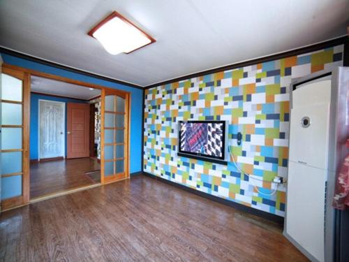 a living room with a wall with colorful tiles at Ahnmyeondo green house in Chaphwa-gol