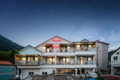 a large white building with a clock on top of it at Geoje Ocean Love Pension in Geoje 
