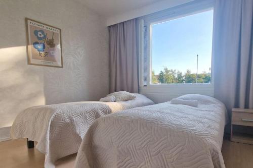 two beds in a bedroom with a window at Villa Ruths Stay Pelto in Kouvola
