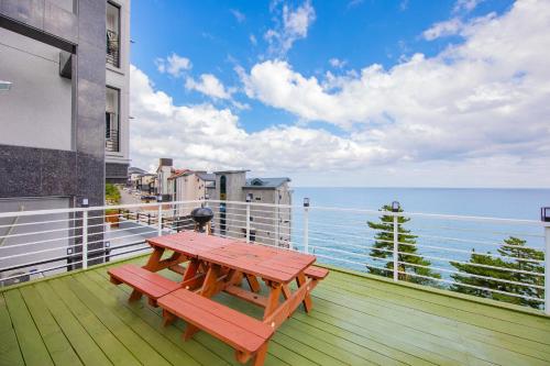 a picnic table on a balcony with a view of the ocean at Samcheok eastocean in Samcheok