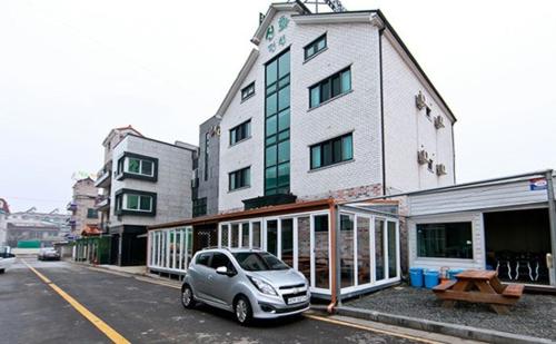 a small car parked in front of a building at Daecheon sinhwa pension in Boryeong