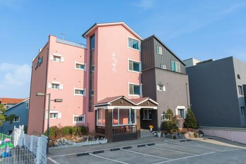a pink building in front of a parking lot at Gyeongju Cookie and Jelly Pension in Gyeongju