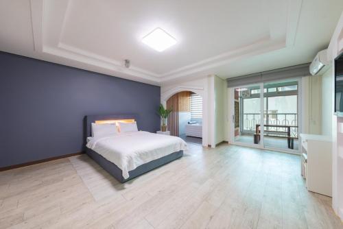 a bedroom with a bed and a blue wall at Gyeongju Cookie and Jelly Pension in Gyeongju