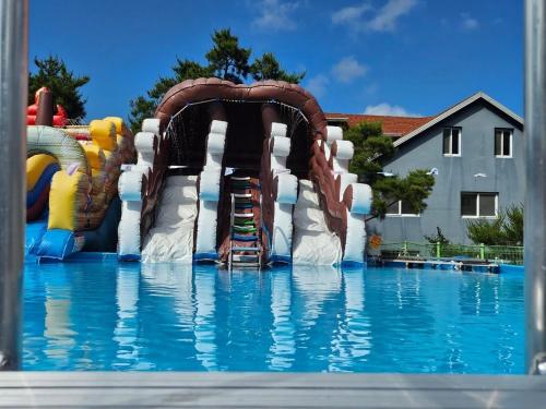 a water slide in the middle of a swimming pool at Gyeongju Cookie and Jelly Pension in Gyeongju