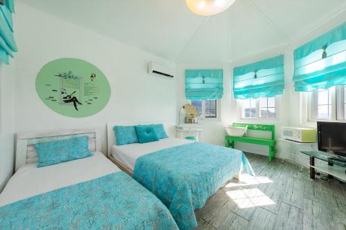 a bedroom with two beds and a flat screen tv at Gwanghwa Concert Pension in Incheon