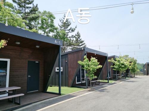 a row of buildings with trees in front of them at Forest Caravan Pension Incheon in Incheon