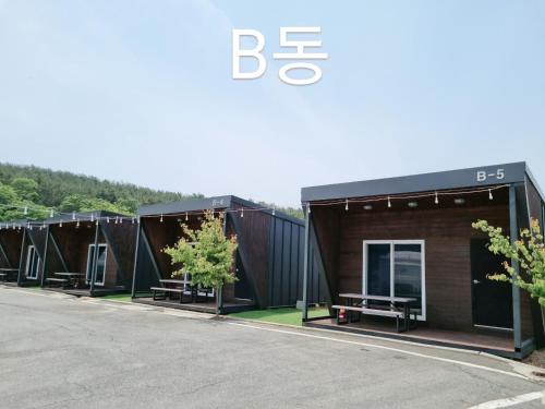 a row of black shipping containers with trees in them at Forest Caravan Pension Incheon in Incheon