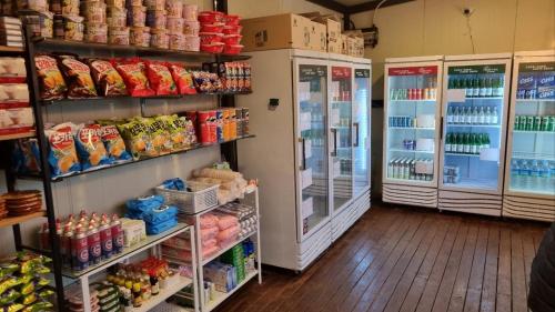 a grocery store aisle with refrigerators and food at Forest Caravan Pension Incheon in Incheon