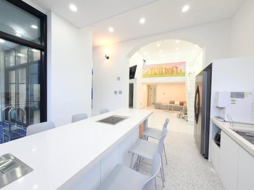 a kitchen with white counters and white chairs at Gapyeong Turu Kids Poolvilla in Gapyeong