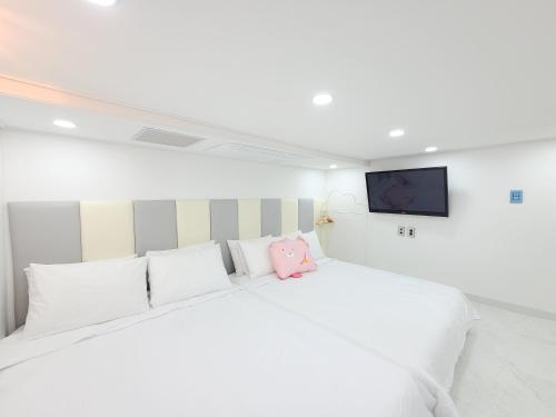 a white bed with a pink stuffed animal sitting on it at Gapyeong Turu Kids Poolvilla in Gapyeong