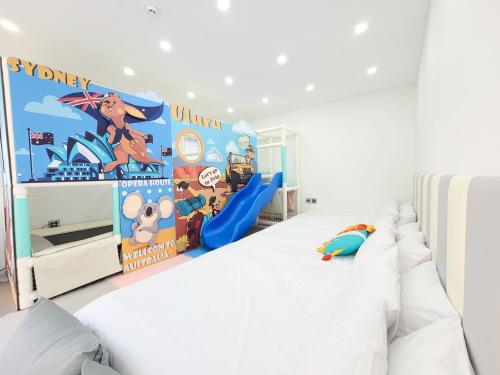 a bedroom with a white bed and a play area at Gapyeong Turu Kids Poolvilla in Gapyeong